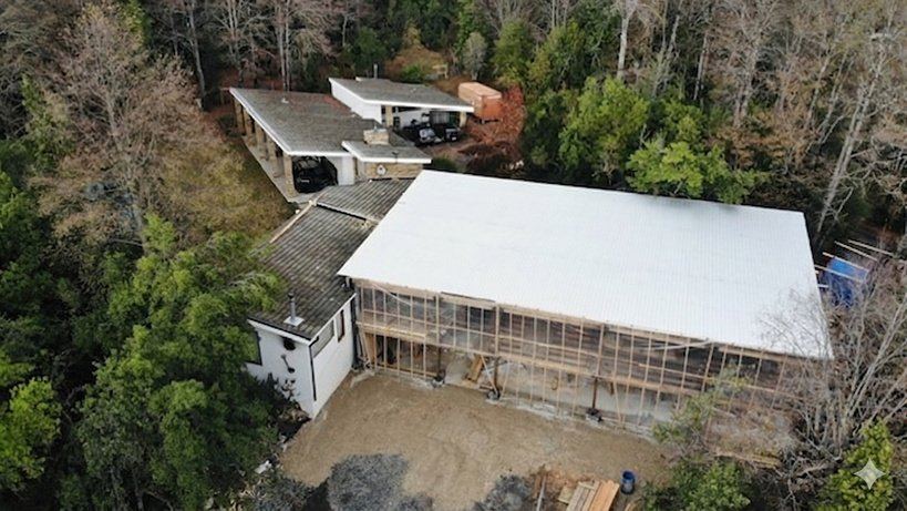 Vista aérea de una casa en construcción entre el bosque
